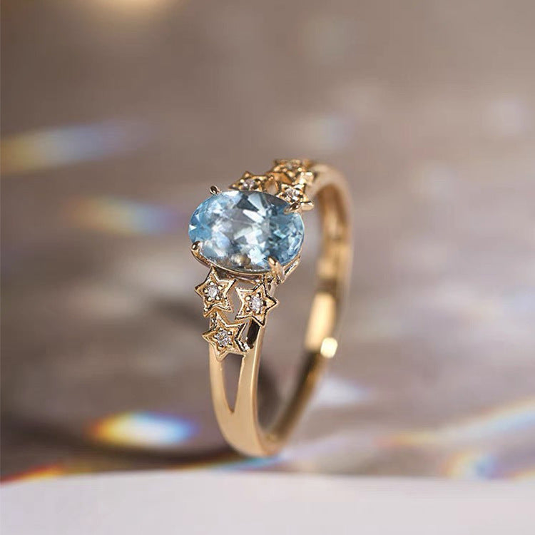 Luxurious Gold Ring Featuring a Stunning Blue Crystal